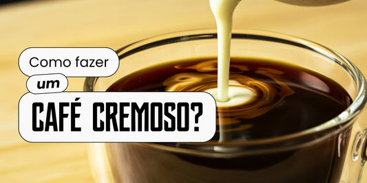 Leite sendo despejado em xícara de café, formando desenho cremoso na superfície da bebida