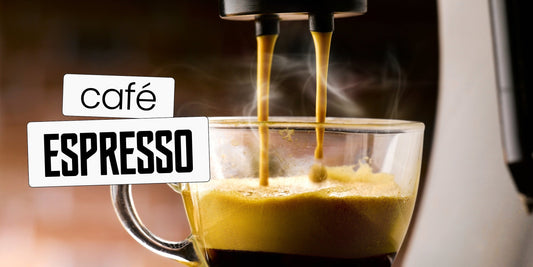 Extração de café espresso em máquina, com jato dourado caindo em xícara de vidro e crema se formando na superfície