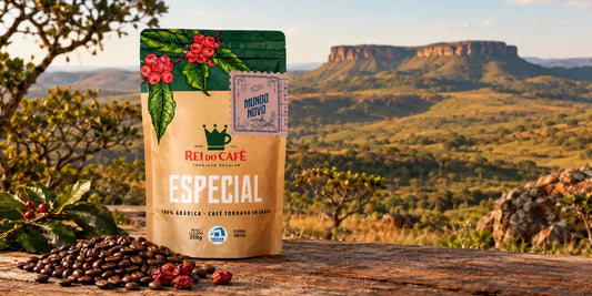 Pacote de café especial Rei do Café Mundo Novo sobre mesa de madeira com paisagem de serra e Cerrado mineiro ao fundo