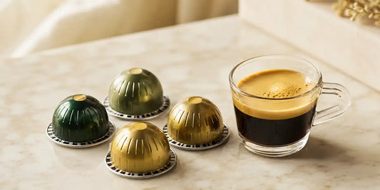 Cápsulas descafeinadas Nespresso em tons de verde e dourado sobre mármore com xícara de espresso