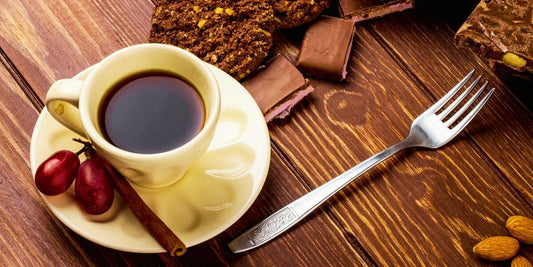 Xícara de café mostrando o equilíbrio entre doçura e amargor no café, com chocolate e uvas ao fundo