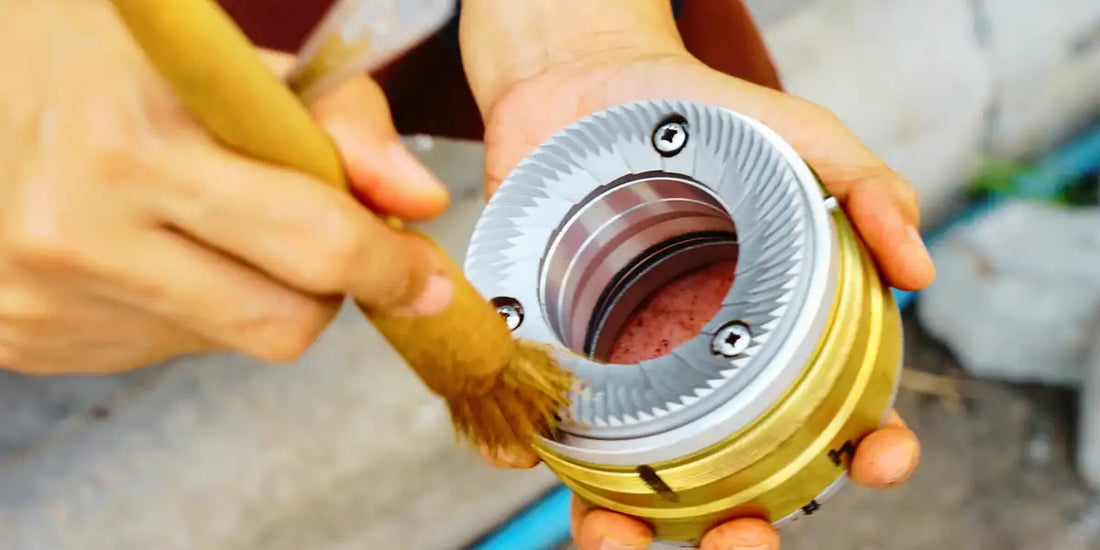 Escovando a câmara e as mós de um moedor de café para remover pó residual