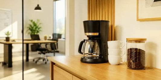 Estação de café em escritório organizada por zonas de preparo, serviço e insumos