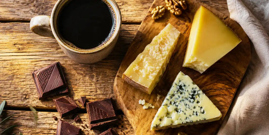 Harmonização com café: xícara de café especial ao lado de chocolate amargo e queijo artesanal em tábua de madeira
