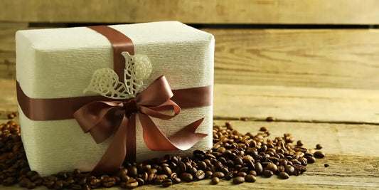 Caixa de presente com laço marrom sobre grãos de café torrados