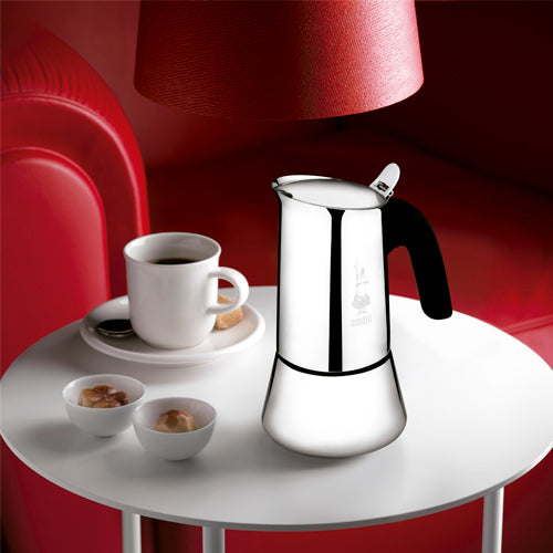 Cafeteira italiana Bialetti Venus inox servida na mesa com xícara de café