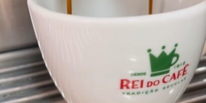 Imagem de uma xícara branca com a logo do Rei do Café que participou do 8º festival Santos Café