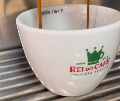 Imagem de uma xícara branca com a logo do Rei do Café que participou do 8º festival Santos Café